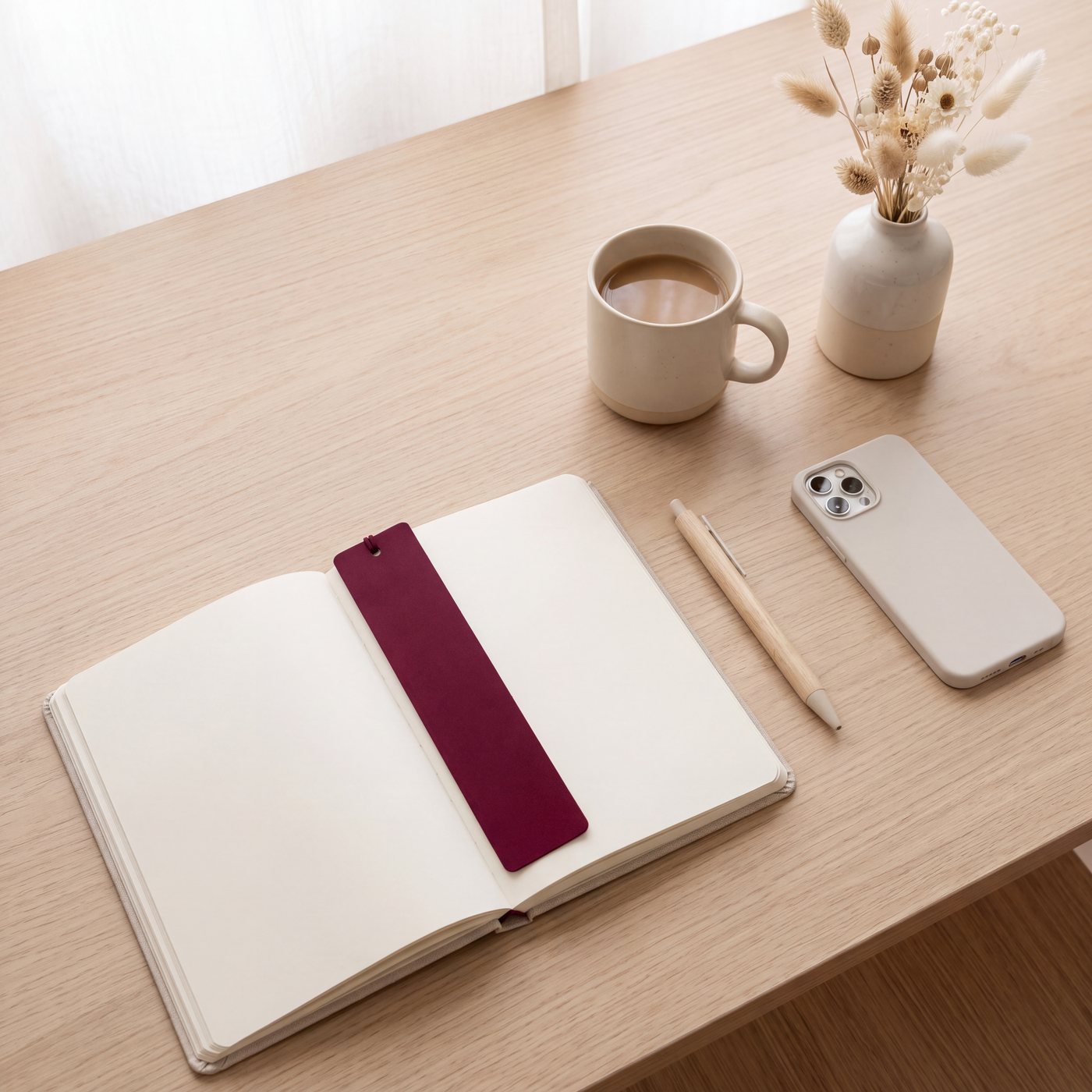 Agenda ouvert et fleurs séchées sur un bureau clair
